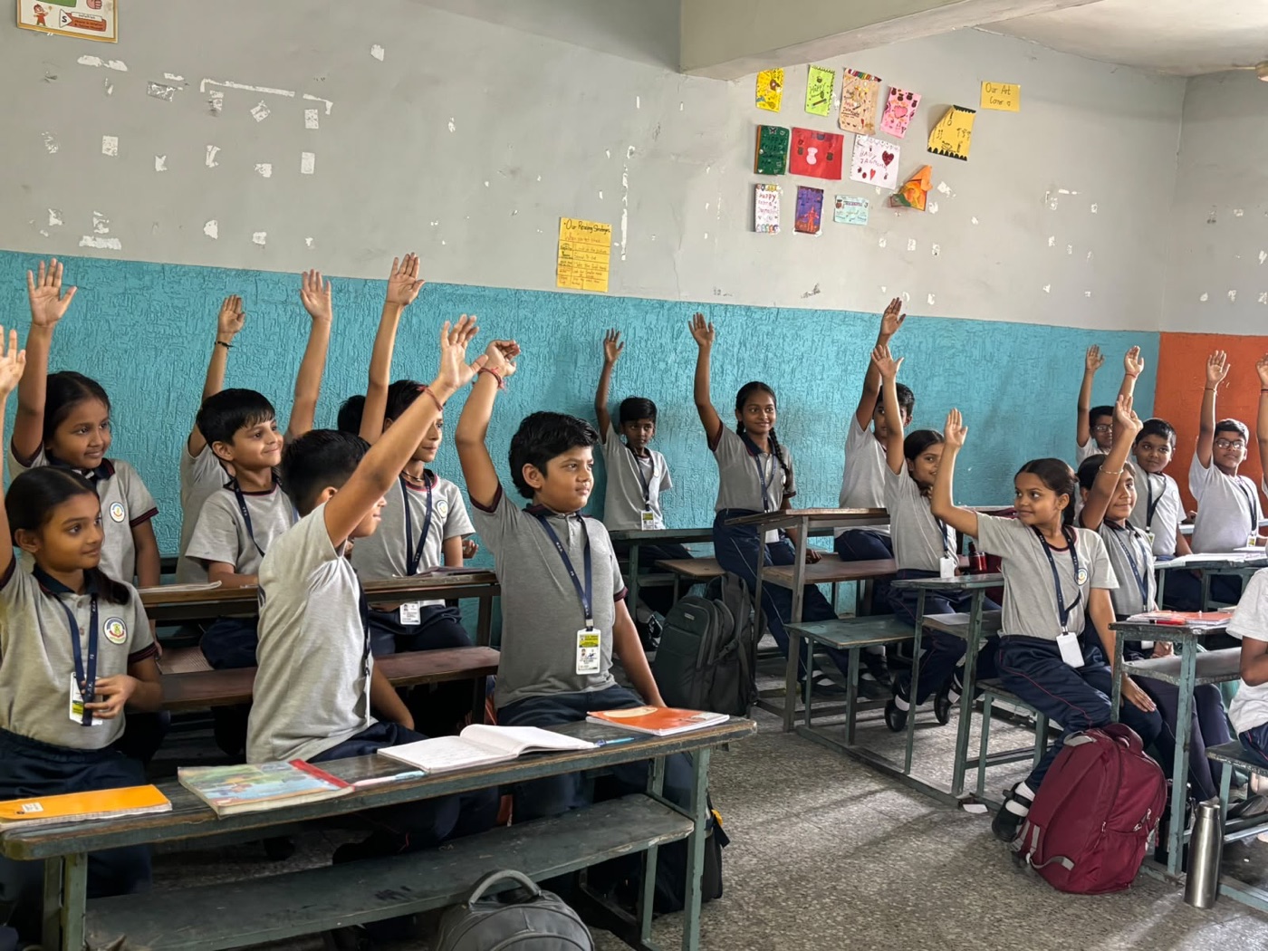 Students raising their hands in an EFAS classroom at KGK School, Ahmedabad
